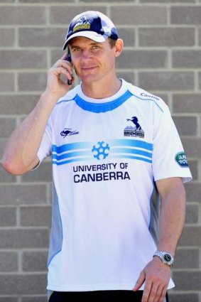 Brumbies coach Stephen Larkham receives a call during training.
