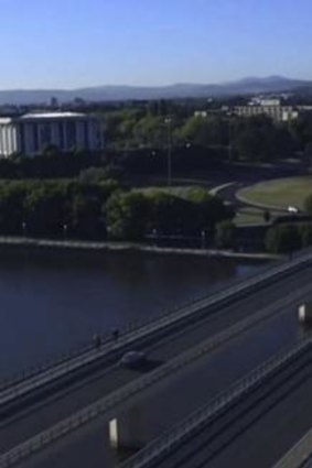 The opening shot of Canberra in Episode 1 of <i>The Code</i>: An aerial view of a car crossing Commonwealth Avenue bridge towards Parliament House.