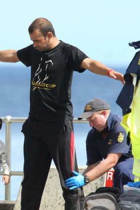 An Afghan asylum seeker is searched by Australian Customs after arriving on Christmas Island in April.