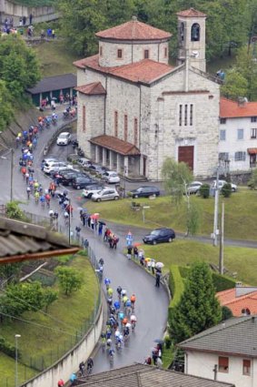 Washed out ... spectators shelter under umbrellas as the peloton arrives in Lecco during stage 15 of the Giro d'Italia.