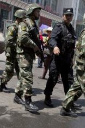 Ongoing violence: Armed Chinese paramilitary policemen march past the site of an explosion outside the Urumqi South Railway Station in Urumqi in north-west China in May.