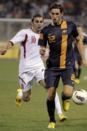 Jordan's forward Ahmed Hayel challenges Australia's  Matthew Spiranovic.