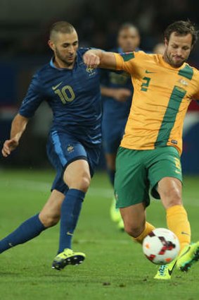 Lucas Neill is challenged by Karim Benzema in the friendly against France.
