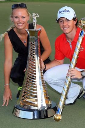 Rory McIlroy and his girlfriend, top tennis player Caroline Wozniacki, pose with the trophy.