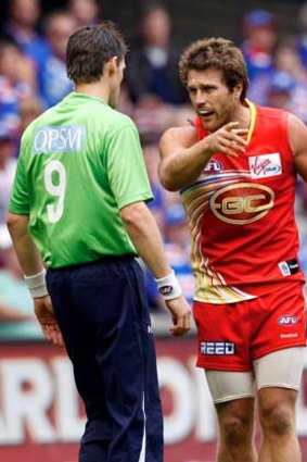 An emergency umpire speaks to Campbell Brown after an off-the-ball incident in 2011.