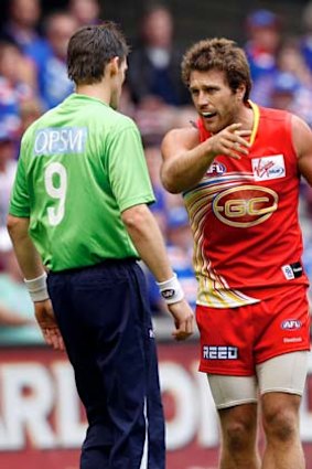 An emergency umpire speaks to Campbell Brown after an off-the-ball incident in 2011.