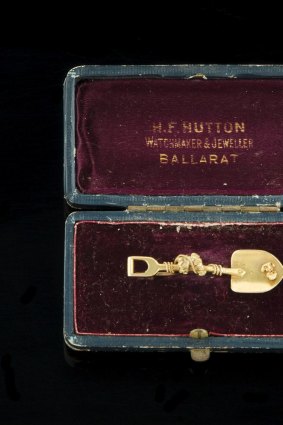 Rare: 18 carat yellow gold bar brooch in the form of a shovel with applied nugget and rope, in the original presentation box supplied by H.F.Hutton of Ballarat. 