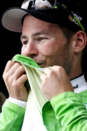 Mark Cavendish kisses the green jersey while on the podium after winning the 11th stage.