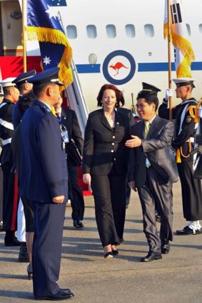 Julia Gillard walks past a military guard shortly after her arrival at the military airbase in Seoul.