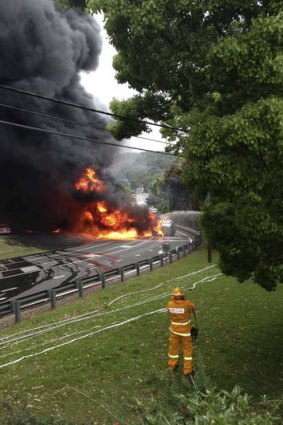 Fatal crash: The wreckage of a Cootes truck burns on Mona Vale Rd after it crashed killing two men.