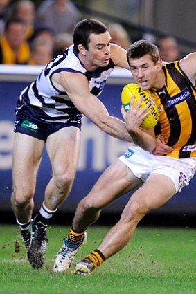 Geelong defender Matthew Scarlet tackles Hawk Brendan Whitecross.
