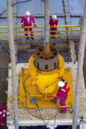 Workers on the Transocean Discoverer Inspiration prepare to deploy a flange overshot tool.