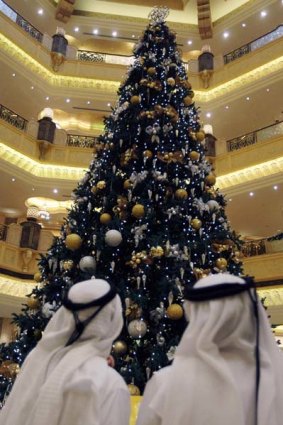 Two Emirate men look to a Christmas tree which has been decked out with dollars $11m worth of gold, at the Emirates Palace hotel, in Abu Dhabi, United Arab Emirates.