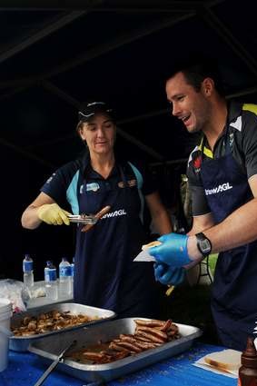Capitals coach Carrie Graf and Raiders Brett White man the sausage sizzle.