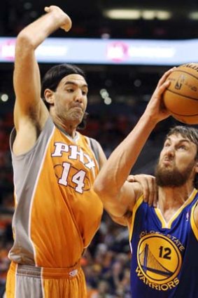 Not quite ready ... centre Andrew Bogut takes on Luis Scola during the Warriors' season opener against Phoenix.