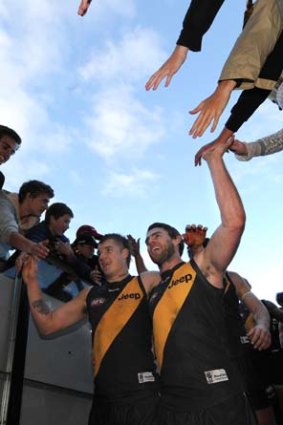 Finals bound: Chris Newman (right) and Dustin Martin high-five the fans after Richmond's win over Fremantle.