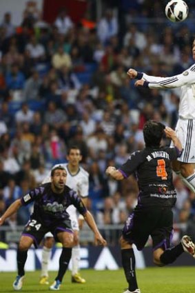 Real Madrid's Cristiano Ronaldo (right) heads the ball past Real Valladolid's Marc Valiente (centre) and Mikel Balenziaga during the Spanish first division soccer match in Madrid.