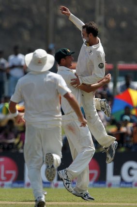 Australia cricketer Nathan Lyon (right) celebrates with his teammates after taking one of his five wickets in just his first Test.