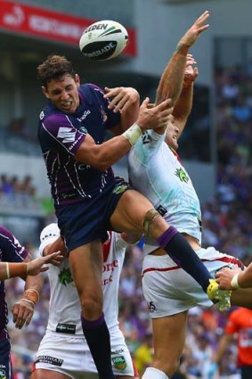 Aiming high: The Storm's Billy Slater leaps for the ball in their game against the Dragons.