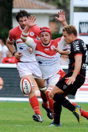 Biarritz's flanker Wenceslas Lauret (C) and Thibault Dubarry (L) tries to chargedown a kick by Toulon's Jonny Wilkinson.