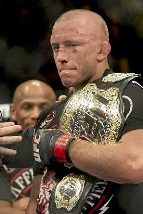 Georges St-Pierre holds the belt after defeating Carlos Condit in their UFC welterweight title fight.