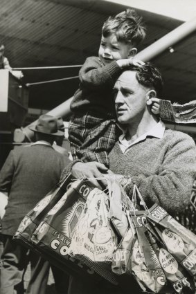 Keith Pell and his seven-year-old son Lindsay with lots of showbags at the Royal Melbourne Show in 1963.
