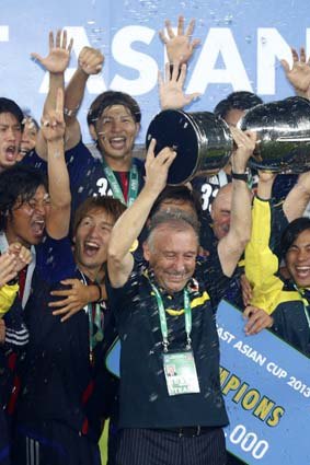 Japan's coach Alberto Zaccheroni raises the trophy as the team celebrates winning the East Asian Cup championship in Seoul on Sunday.