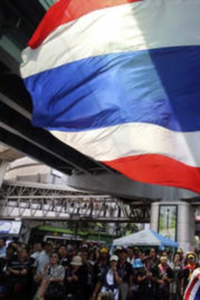An anti-government protester waves the Thai flag.