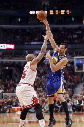 Golden State Warriors centre Andrew Bogut passes the ball over Chicago Bulls forward Carlos Boozer in Chicago.