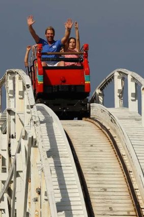 Shane Warne rides the scenic railway with children during the Shane Warne Foundation Family Day at Luna Park on Tuesday.