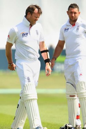 Graeme Swann winces after being hit by the ball during the match against Essex on Monday. To his right is paceman Tim Bresnan.