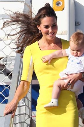 A bright yellow ensemble: The Duchess disembarks the plane with Prince George.