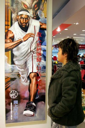 A Chinese shopper walks past an advertisement featuring NBA star LeBron James in Beijing.