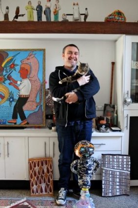 Glenn Barkley at home in Redfern with his collection and moggie.