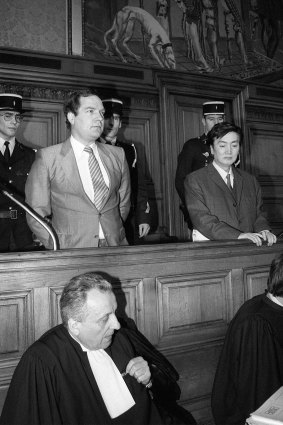Bernard Boursicot, left,  shares the defendant's box with co-defendant Shi Pei Pu  in May 1986 as their espionage trial opens at Paris Justice Palace.