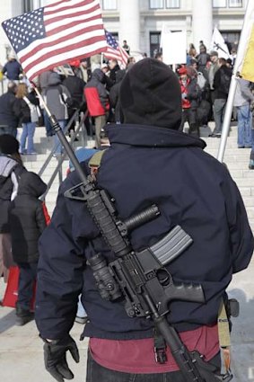 Fired up &#8230; Nate Rodriguez, of West Valley City, Utah, carries his AR-15 with a flag in the barrel outside the Utah Capitol.