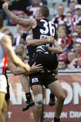 Dane Swan celebrates a crucial grand final replay goal with teammate Chris Dawes.