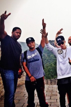 Justin Bieber celebrates with his entourage as they traverse the Great Wall of China.