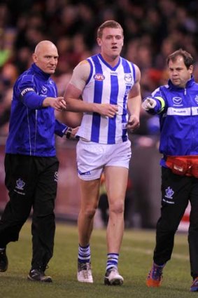 North Melbourne's Lachlan Hansen comes off after suffering suspected concussion at Etihad Stadium.