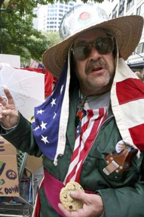 Garth Carroll, who's homeless and calls himself Professor Gizmo, wears the American flag as he demonstrates in Seattle.