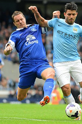 Manchester City's Sergio Agüero vies with Everton's English defender Phil Jagielka.