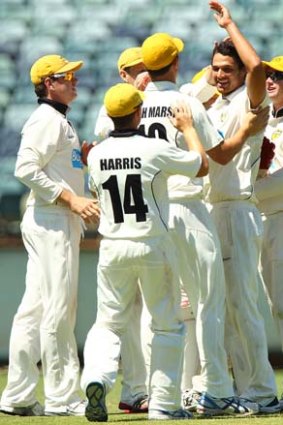 Nathan Coulter-Nile of the Warriors is congratulated by his teammates after he dismissed Michael Klinger of the Redbacks.