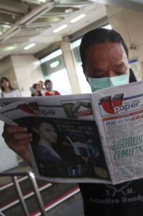 First case confirmed: A Taiwanese man reads a newspaper with headline "Taiwan has confirmed its first case of H7N9" at a subway station in Taipei.