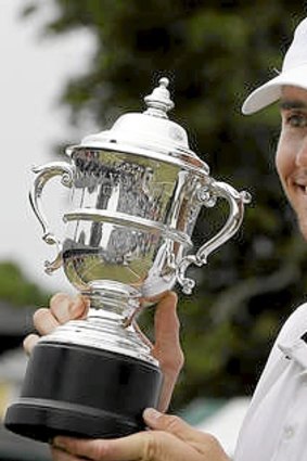 Top seed John Isner holds the Van Alen Cup after defeating Lleyton Hewitt at Rhode Island.