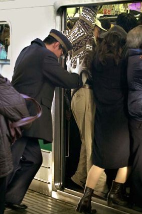 On you get &#8230; a Tokyo attendant pushes in commuters.