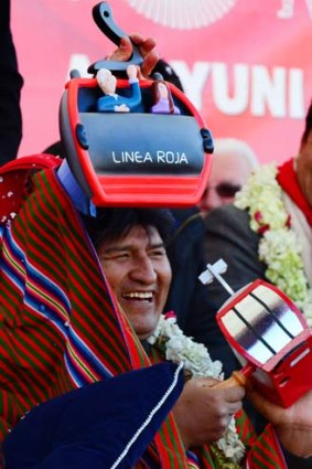 Bolivian President Evo Morales jokes after receiving a replica of the first metropolitan cable railway during its inauguration on May 30, 2014, in La Paz.