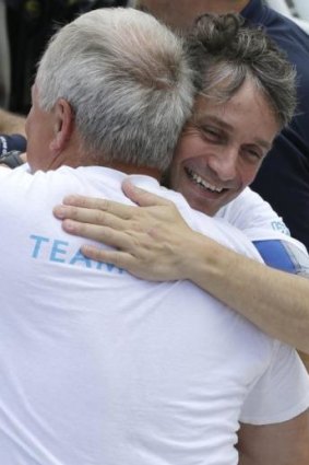 Cousteau hugged by a member of his team as he returns to the dock after 31 days undersea in the Aquarius Reef Base.
