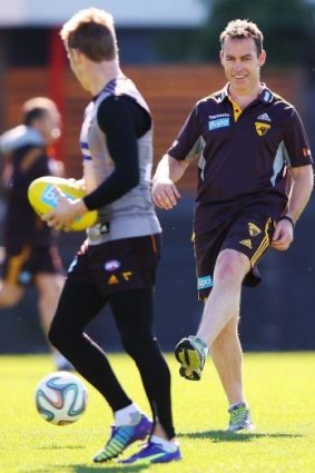 Kicking on: Alastair Clarkson kicks a soccer ball to Sam Mitchell during Hawthorn training on Friday.