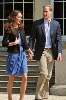 Prince William and Princess Catherine walk outside Buckingham Palace.