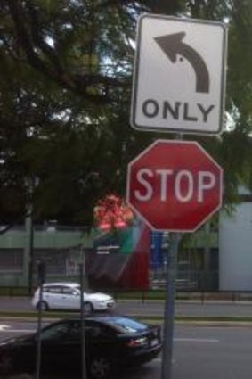 The left turn sign at the corner of Benson Road and Archer Street, at Toowong. Toowong Village is in the background.